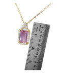 Pink sapphire necklace with gold chain next to a ruler for scale in 14k gold.