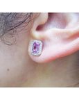 Close-up of an ear wearing a pink sapphire gemstone earring.