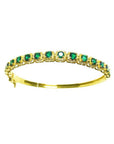 A 14k gold bangle bracelet with round cut natural colombian emeralds brilliant cut sparkling bluish green color.