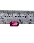 1.11 carat emerald cut natural ruby gemstone, deep red, displayed against a ruler.