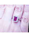 Women's 14K white gold ring with an emerald-cut deep red ruby and diamond halo.
