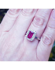 Women's 14K white gold ring with an emerald-cut deep red ruby and a halo of sparkling diamonds.