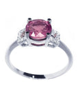Round cut pinkish-red ruby ring with accented diamonds, prong set in 14k white gold.