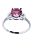 Round cut pinkish-red ruby ring with accented diamonds, prong set in 14k white gold.