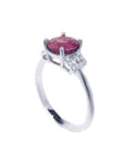 Round cut natural ruby ring with pinkish-red stone, accented diamonds, set in 14k white gold.