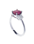 Round cut natural ruby ring with pinkish-red stone, accented diamonds, set in 14k white gold.