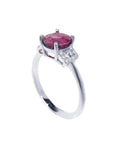 Round cut natural ruby ring with pinkish-red stone, accented diamonds, set in 14k white gold.