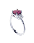 Round cut natural ruby ring with pinkish-red stone, accented diamonds, set in 14k white gold.