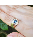 Men's 18K yellow gold ring with east-west bezel-set blue sapphire and diamond accents.