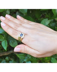 Men's 18K yellow gold ring with an east-west bezel-set blue sapphire and diamond accents.
