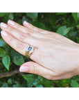 Men's 18K yellow gold ring with an east-west bezel-set blue sapphire and diamond accents.