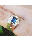 Men's 18K yellow gold ring with east-west bezel-set blue sapphire and diamond accents.