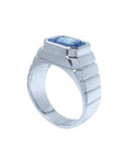 Men's 18K white gold ring with a bezel-set, emerald-cut vivid blue sapphire.