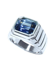 Blue sapphire ring for men emerald cut east west bezel set made of 18K white gold.
