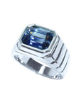 Blue sapphire ring for men emerald cut east west bezel set made of 18K white gold.