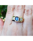 14k gold ring with a blue natural sapphire gemstone emerald cut bezel set vibrant medium blue accented by side diamonds.