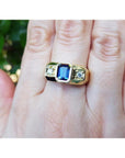 14k gold ring with a blue natural sapphire gemstone emerald cut bezel set vibrant medium blue accented by side diamonds.