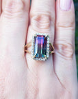 Women's 14K gold ring with a rectangular 5.60 ct. green and pink watermelon tourmaline, surrounded by diamonds.