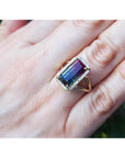 Watermelon tourmaline ring with green and pink rectangular gemstone, surrounded by diamonds on a 14K gold band.