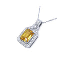 Emerald cut yellow sapphire pendant with halo diamonds on an 18K white gold chain.