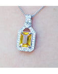 Hanging on a woman's neck a natural yellow sapphire pendant necklace halo diamond 18k white gold
