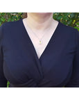 Woman wearing a 2.42 ct. emerald-cut yellow sapphire and diamond halo pendant on an 18K white gold chain.