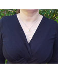 Woman wearing a 2.42 ct. emerald-cut yellow sapphire and diamond halo pendant on an 18K white gold chain.