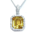 Natural yellow sapphire pendant showcasing a vibrant medium-light hue halo diamonds handcrafted in 18k white gold.