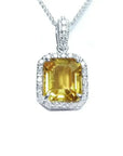 Natural yellow sapphire pendant showcasing a vibrant medium-light hue halo diamonds handcrafted in 18k white gold.