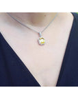 From a woman's neck pending a yellow sapphire pendant halo diamonds handcrafted in white gold