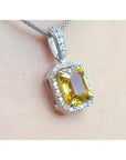 6.01 ct. emerald cut natural yellow sapphire pendant with diamond halo in 18K white gold.