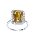 Emerald cut 4.59 ct yellow sapphire ring with diamond halo in 14K white gold.