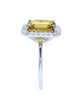 Emerald cut yellow sapphire ring with diamond halo in 14K white gold.