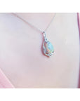 Pear-shaped rainbow Welo Ethiopian opal pendant in sterling silver with cubic zirconia accents on a chain.