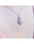 Pear-shaped rainbow Welo Ethiopian opal pendant in sterling silver with cubic zirconia accents on a chain.
