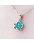 14K white gold emerald cluster necklace with diamond halo, clover-like five-petal design.