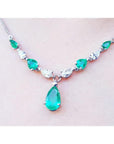 14k white gold necklace with pear-shaped emeralds and diamonds, featuring a large emerald drop pendant.