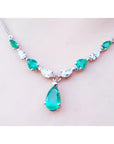 14k white gold necklace with pear-shaped emeralds and diamonds, featuring a large emerald drop pendant.