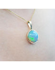 Opal pendant necklace on a plain skin background.