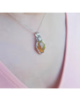 Ethiopian opal pendant with vibrant play of colors and brown pinpoint fire in a silver wire wrap.
