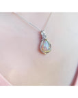Welo Ethiopian multicolor opal pendant with silver wire wrap, worn on a pink top.