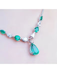 14k white gold necklace with pear-shaped emeralds and diamonds, featuring a large emerald drop pendant.