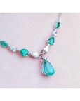 14k white gold necklace with pear-shaped emeralds and diamonds, featuring a large emerald drop pendant.