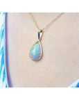Pear-shaped Ethiopian Welo opal pendant in 14K yellow gold, showing fire red-orange and rainbow colors.