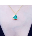 Heart-shaped natural emerald necklace on a person's neck against a white background