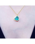 Heart-shaped natural emerald necklace on a person's neck against a white background
