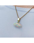 Ethiopian Welo opal pendant with full play of colors, dangling from a 14k gold bail on a chain.