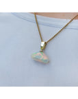 Ethiopian Welo opal pendant with full play of colors, dangling from a 14k gold bail on a chain.