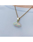 Ethiopian Welo opal pendant with full play of colors, dangling from a 14k gold bail on a chain.