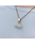 Ethiopian Welo opal pendant with full play of colors, dangling from a 14k gold bail on a chain.